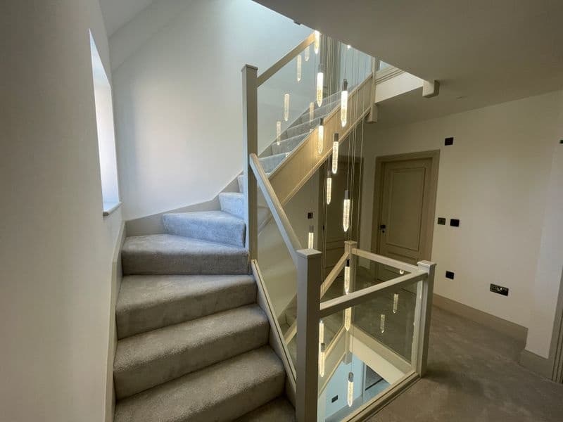 Warm integrated feature lighting beside a residential staircase